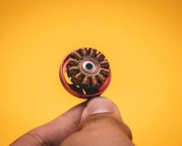 Close-up van een koperen elektromotoronderdeel dat tussen vingers wordt gehouden