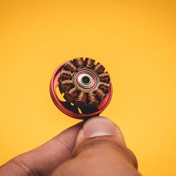 Close-up van een koperen elektromotoronderdeel dat tussen vingers wordt gehouden